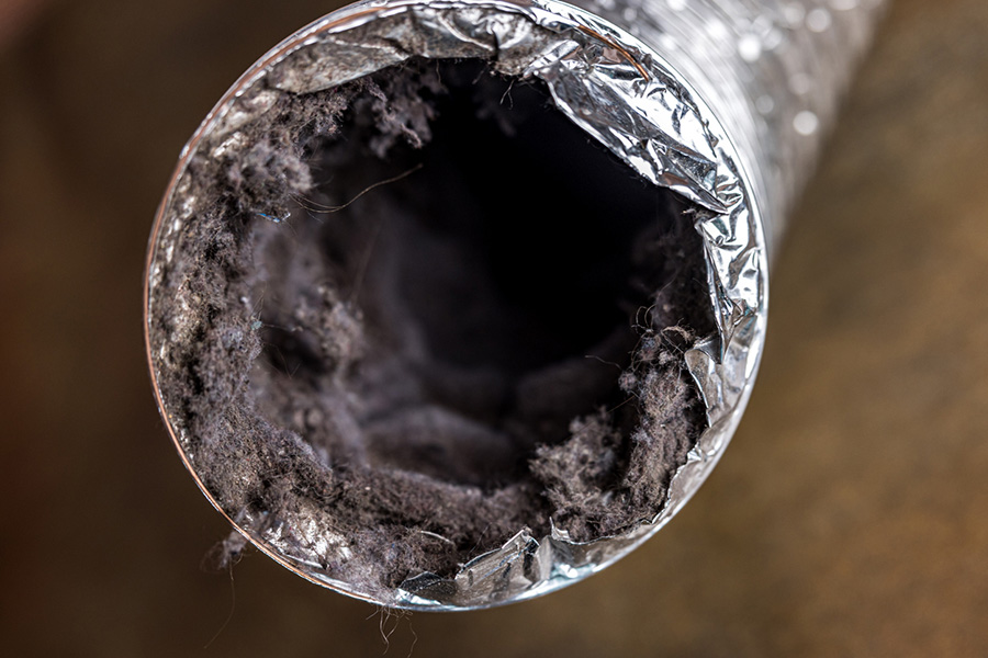 A dirty laundry flexible aluminum dryer vent duct ductwork filled with lint, dust and dirt